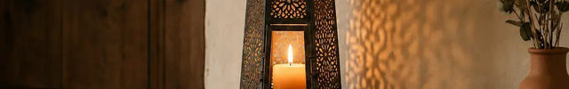 Lanterne décorative marocaine en métal noir avec bougie, mise en scène dans un salon au style rustique et chaleureux avec jeux d'ombres sur le mur.